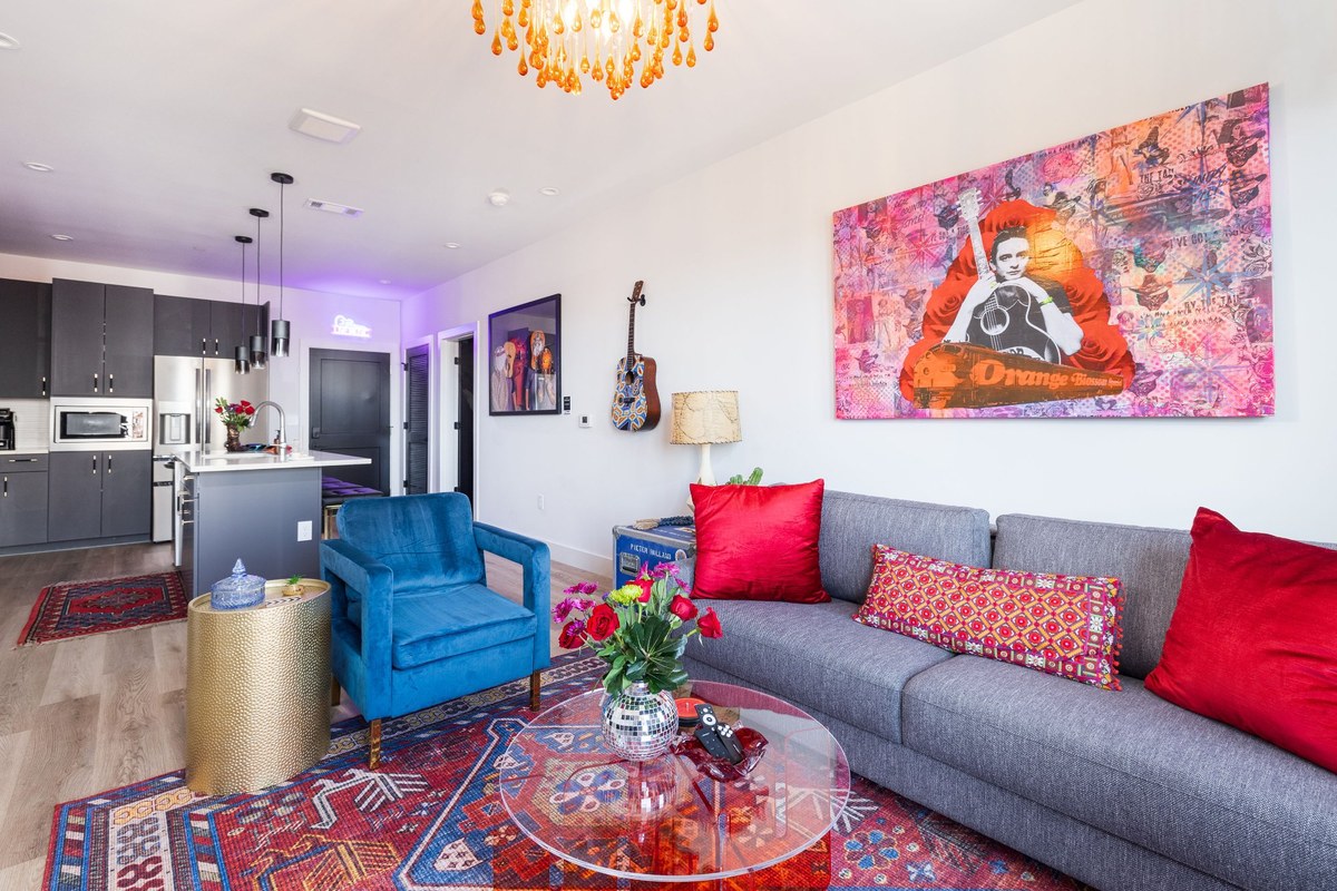 Honky Tonk Party Pad living room — Johnny Cash art, chandelier, open kitchen