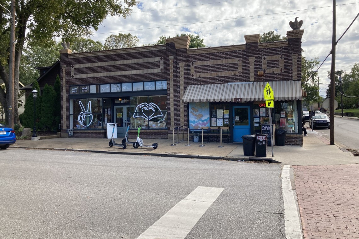East Nashville Fatherland District shopping strip — the historic brick corner storefronts on Fatherland Street with indie boutiques, gift shops, and a neighborhood cafe