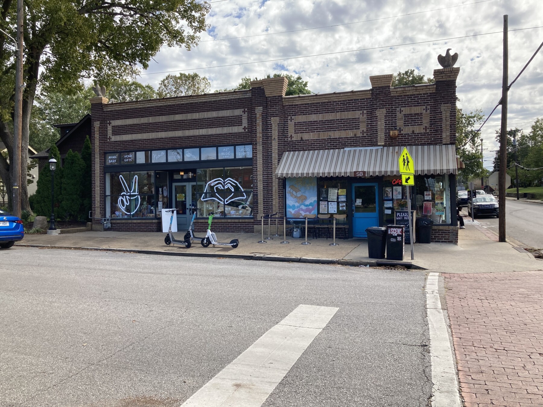 East Nashville Fatherland District shopping strip — the historic brick corner storefronts on Fatherland Street with indie boutiques, gift shops, and a neighborhood cafe